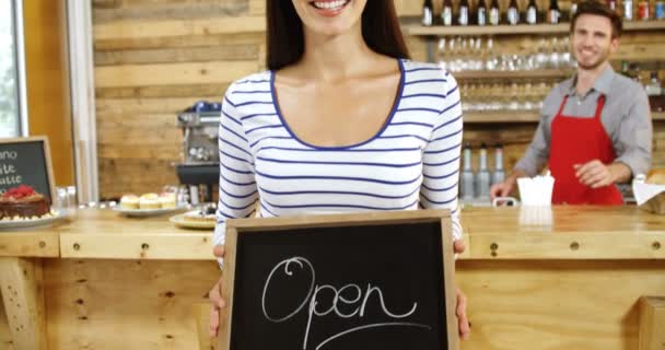 のカフェでオープン看板の立っている女性の肖像画 — ストック動画
