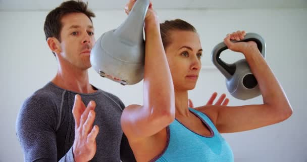 Treinador Ajudando Uma Mulher Exercitar Com Kettlebells Ginásio — Vídeo de Stock