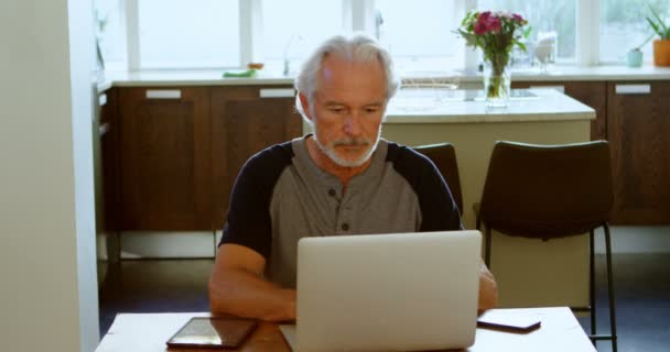 Ανώτερος Άνθρωπος Που Χρησιμοποιούν Φορητό Υπολογιστή Στο Τραπέζι Στο Σπίτι — Αρχείο Βίντεο