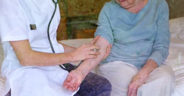 Врач Проверяет Пульс Пожилой Женщины Помощи Стетоскопа Кровати Дома — стоковое видео