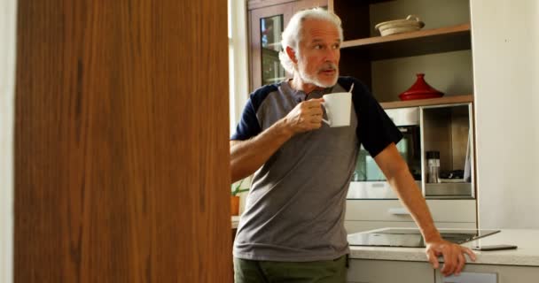 年配の男性がホームの で台所でコーヒーを飲んで — ストック動画