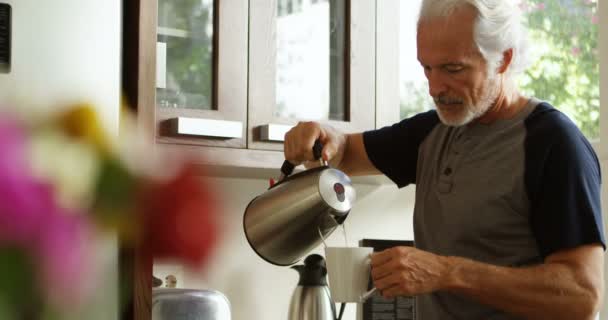 年配の男性がホームの でキッチンでコーヒーを準備します — ストック動画