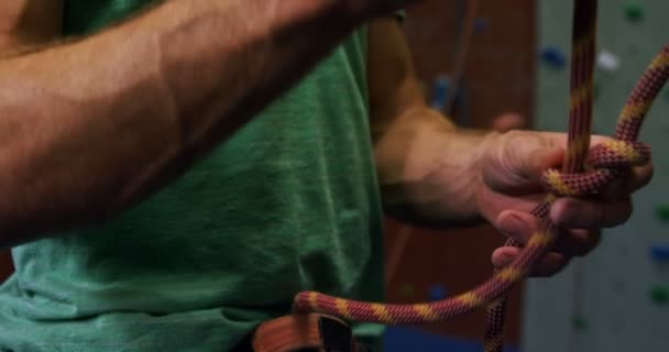 ボルダリング でロープを結ぶ男のクローズ アップ — ストック動画