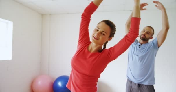 Άνδρας Και Γυναίκα Που Κάνει Τέντωμα Άσκηση Στο Studio Γυμναστικής — Αρχείο Βίντεο