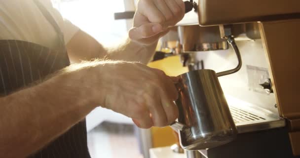 のカフェでコーヒー メーカーのマシンを使用して男性のウェイターの半ばセクション — ストック動画