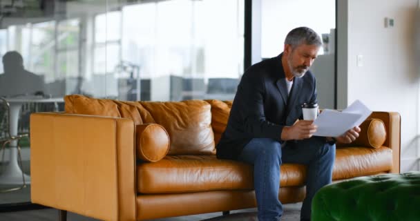 Uomo Affari Con Documento Controllo Tazza Caffè Sul Divano Ufficio — Video Stock