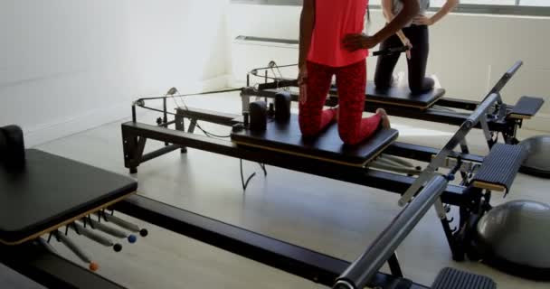 ローイング マシン フィットネス スタジオ で運動をしている女性 — ストック動画