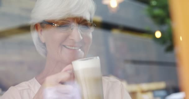 カフェ でミルクセーキを持つアクティブなシニア女性 — ストック動画