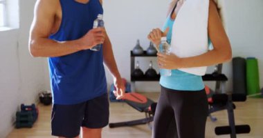 Erkek ve kadın ile su şişeleri 4 k spor salonunda birbirinizle konuşmak