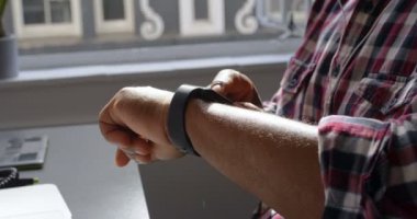 Üst düzey erkek yönetici smartwatch kullanma office 4 k orta bölümünde