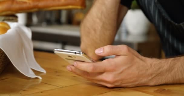Αρσενικό Σερβιτόρος Χρησιμοποιώντας Κινητό Τηλέφωνο Στο Μετρητή Καφέ — Αρχείο Βίντεο