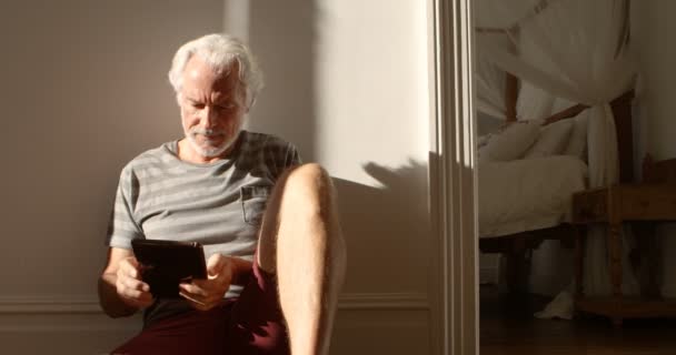 Lächelnder Senior Mit Digitalem Tablet Auf Dem Fußboden Hause — Stockvideo