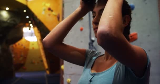 在抱石赛体育馆攀登人工墙前戴安全帽的妇女4K — 图库视频影像