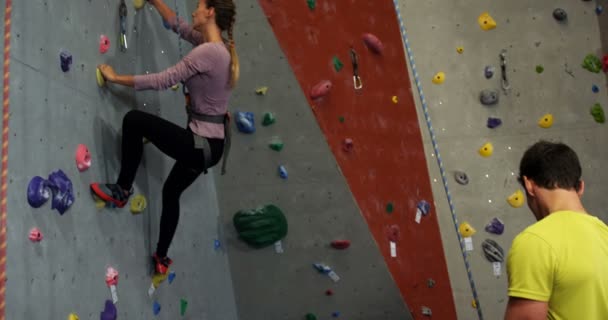 Coach Hjälpa Kvinna Den Konstgjorda Klättervägg Bouldering Gym — Stockvideo