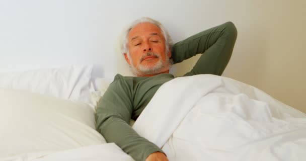 年配の男性が の自宅の寝室でベッドでリラックス — ストック動画