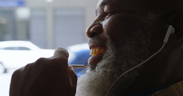 Hombre Negocios Senior Usando Sus Auriculares Mientras Habla Por Teléfono — Vídeo de stock