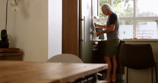 年配の男性がホームの でキッチンでコーヒーを準備します — ストック動画