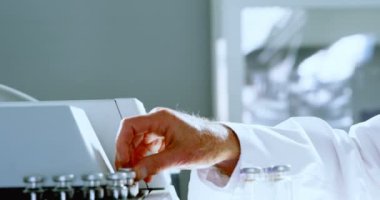 Laboratuvar 4 k bir rafa tıbbi şişeleri yerleştirerek erkek bilim adamı