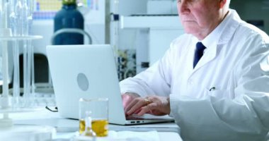 Laboratuvarda 4 k dizüstü kullanarak erkek bilim adamı