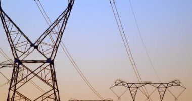 Günbatımı gökyüzü karşı yüksek gerilim elektrik direkleri