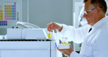 Laboratuvar 4 k bir rafa tıbbi şişeleri yerleştirerek erkek bilim adamı