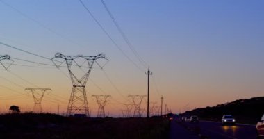 Gün batımı sırasında yüksek gerilim alan elektrik direkleri