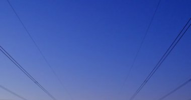 Yüksek gerilim powerlines ve gün batımı sırasında elektrik direkleri karayoluyla