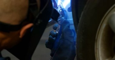 Bir araba garajında 4 k wielding meşale kullanarak makinist