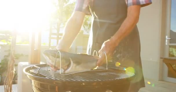 在后院烧烤时准备鱼的资深男士4K — 图库视频影像