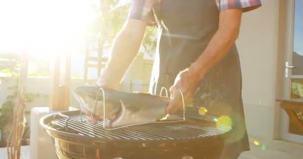 Starší Muž Připravuje Ryby Grilu Zahradě — Stock video