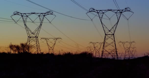 Υψηλής Τάσης Ηλεκτρικό Πόλων Κατά Ηλιοβασίλεμα Στην Εξοχή — Αρχείο Βίντεο