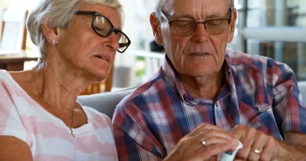 Senior Paar Bespreken Van Medicatie Bank Bij Huis — Stockvideo