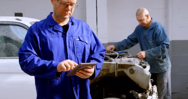 Mechaniker Schaut Kamera Während Digitales Tablet Der Garage Benutzt — Stockvideo