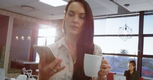 Femme cadre parlant sur téléphone portable tout en prenant un café dans la cafétéria de bureau 4k 