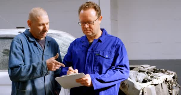 Dos Mecánicos Escribiendo Portapapeles Garaje Reparación — Vídeos de Stock
