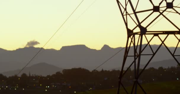 Χαμηλή Γωνία Προβολής Της Υψηλής Τάσης Ηλεκτρική Πόλο Κατά Ηλιοβασίλεμα — Αρχείο Βίντεο