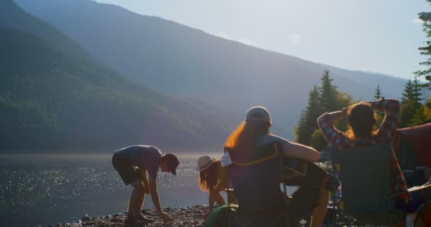 一群朋友在阳光明媚的日子在河边露营4K — 图库视频影像