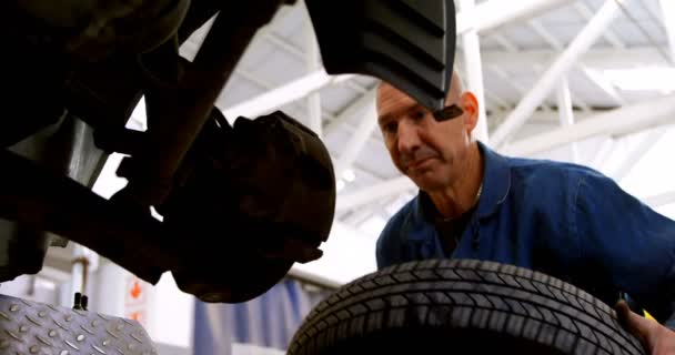 Niski Kąt Widzenia Mechanik Mocowania Koła Samochodu Garażu — Wideo stockowe