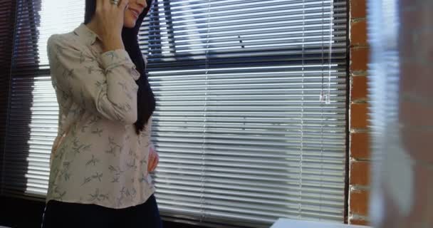 女性行政人员在办公4K 中谈论手机的侧面观点 — 图库视频影像