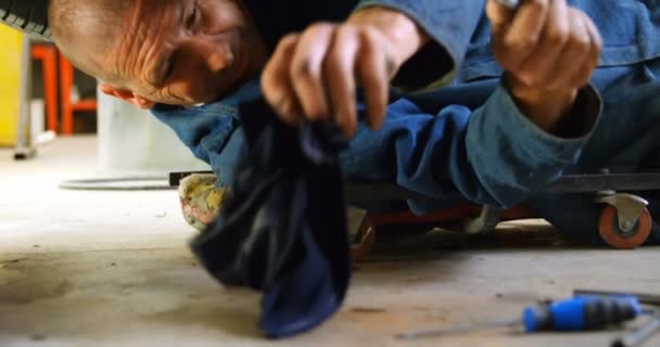 Mécanicien utilisant une serviette lors de la réparation d'une voiture dans le garage 4k 