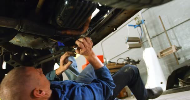 Μηχανικός Εξετάζει Ένα Αυτοκίνητο Στο Γκαράζ Επισκευής — Αρχείο Βίντεο