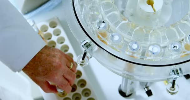 男性の科学者が研究室では の遠心から医療バイアルを削除します — ストック動画