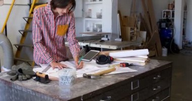 Kadın marangoz atölyesinde 4 k bir plan üzerinde çalışıyor