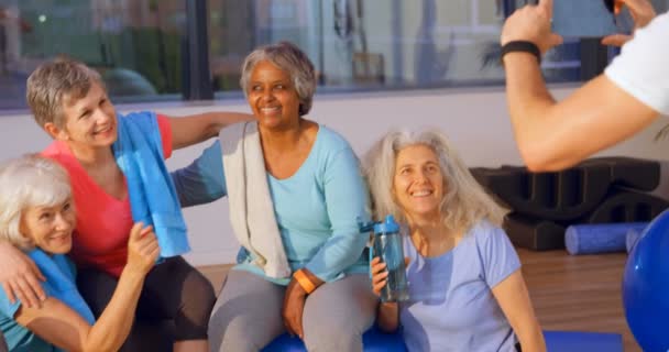 Entrenador Tomando Fotos Mujeres Mayores Teléfono Móvil Centro Yoga — Vídeos de Stock