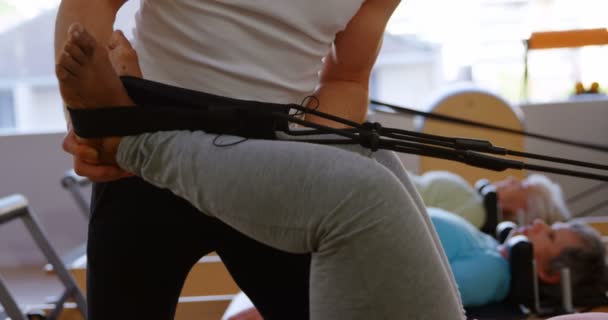 Trener Pomoc Starszych Kobiet Podczas Stretching Ćwiczenia Jogi Centrum — Wideo stockowe