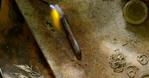 Gros plan du concepteur de bijoux soudure morceau de métal dans l'atelier 4k 