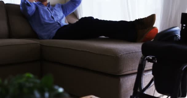 ホーム でソファの上の仮想現実のヘッドセットを使用して無効になった男 — ストック動画
