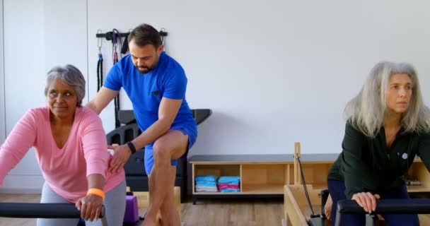 Trainer Assisting Senior Women Performing Yoga Yoga Center — Stock Video