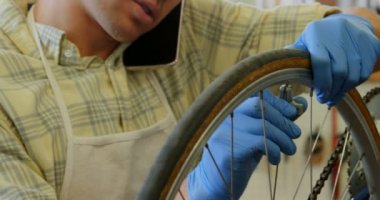 Bisiklet atölyesinde 4 k kısayollarımı cep telefonda konuşan adam