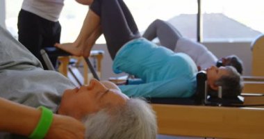 Yoga merkezi 4 k yoga yaparken üst düzey kadın talimat eğitmen